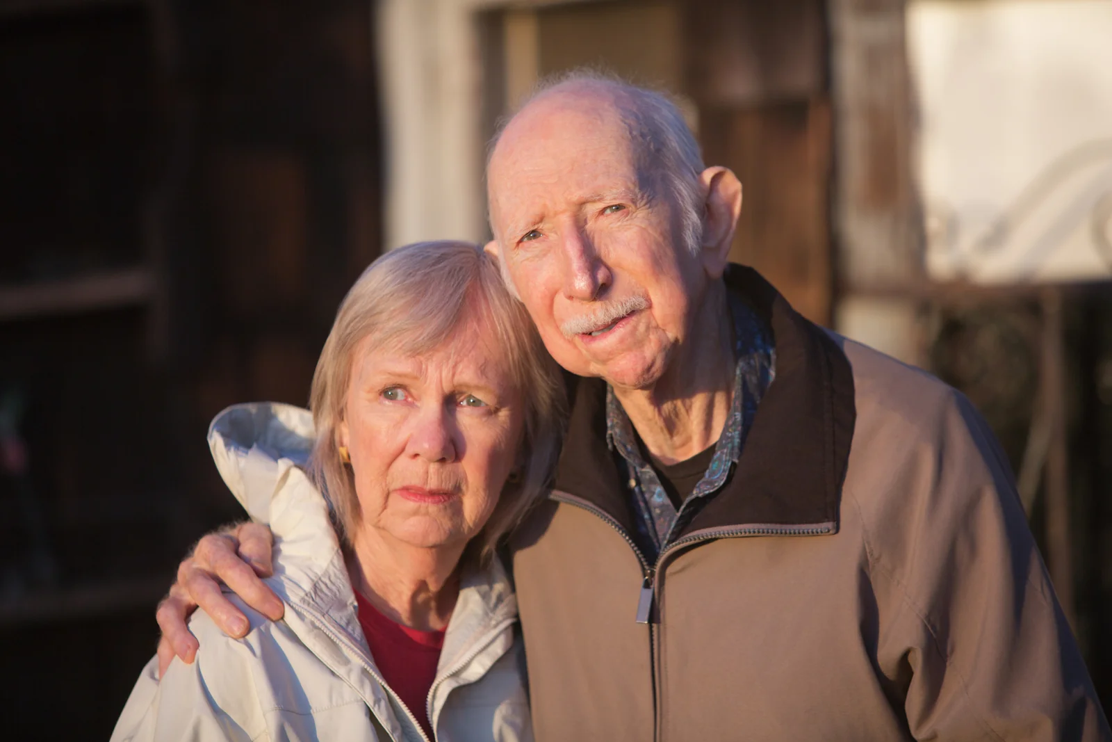 Older couple standing together with the man's arm around the woman